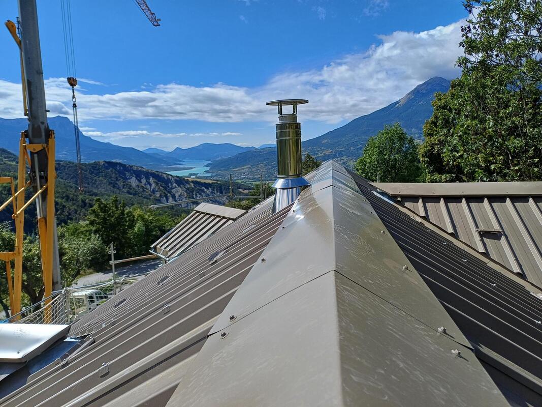 Couverture bac acier sur maison ossature bois paille et toiture paille.